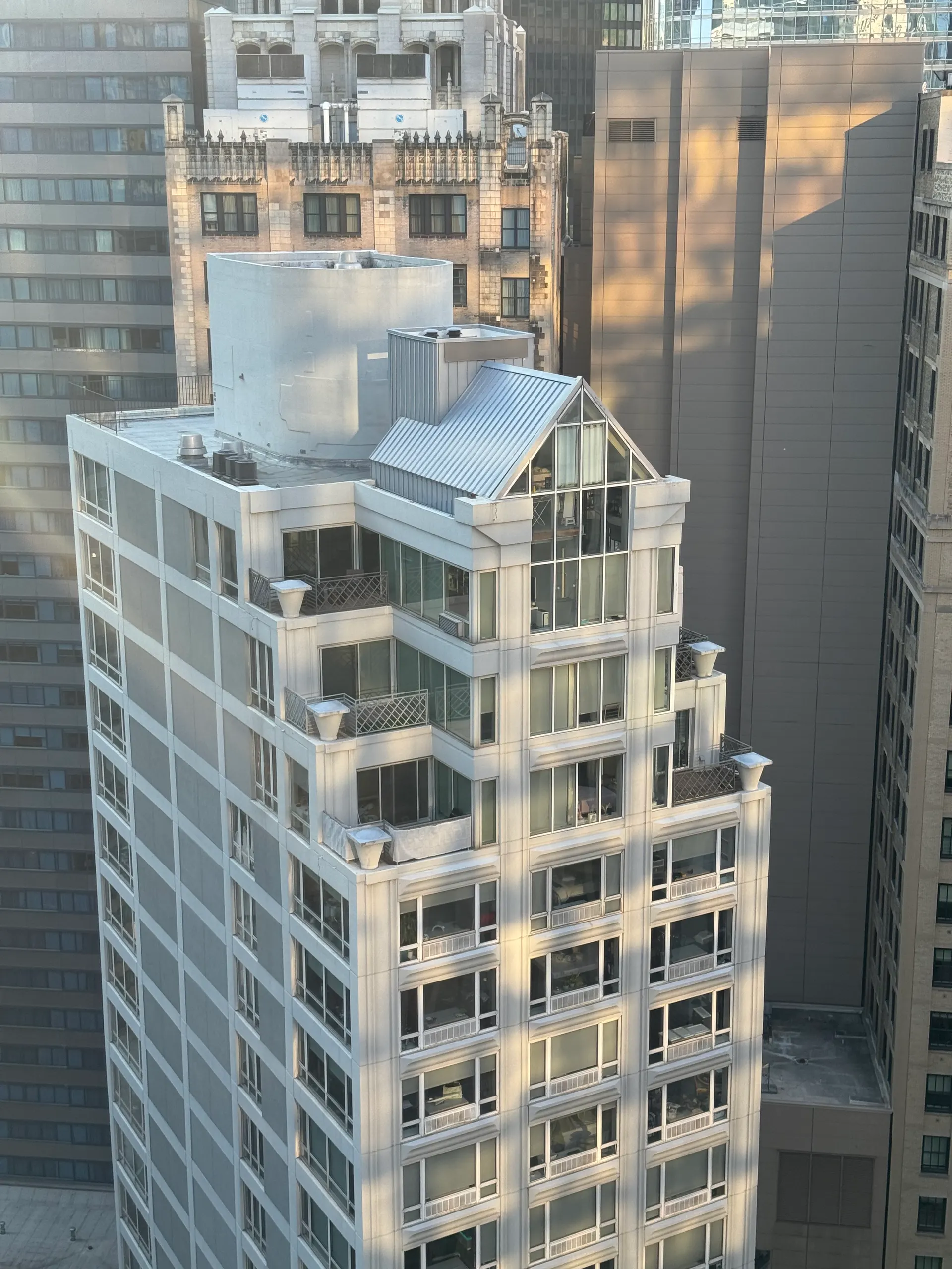 Golden-hour light raking across the upper floors of a dense cluster of city towers.