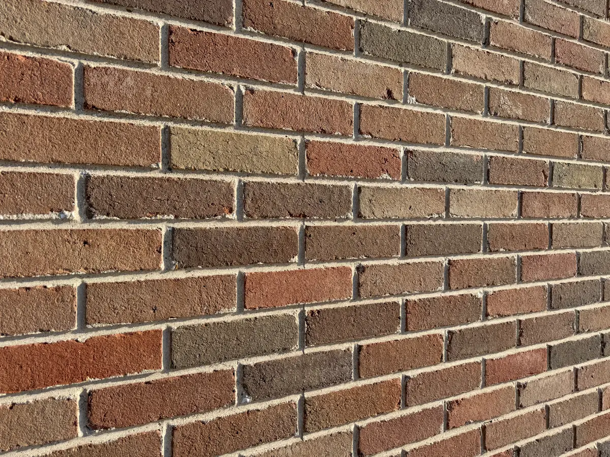 Finished embedded-brick precast panel face in raking sunlight.