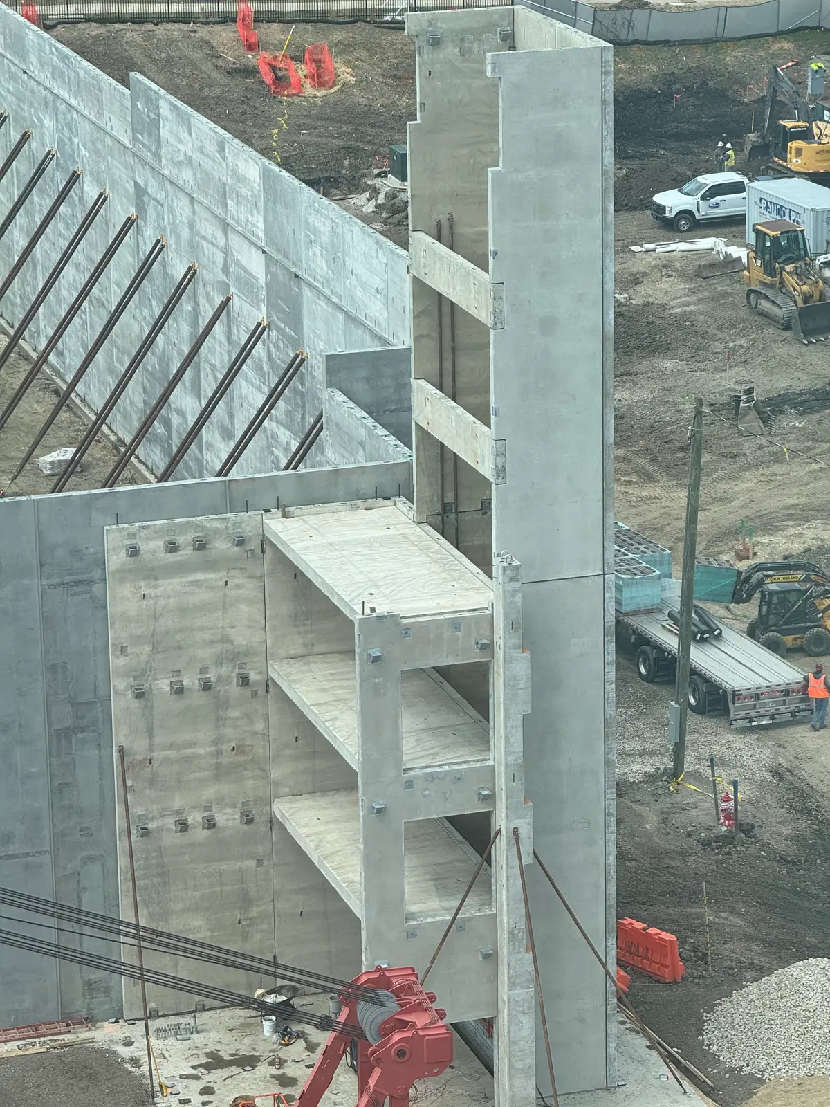 Precast concrete stair and wall units being erected on a jobsite, seen from above.